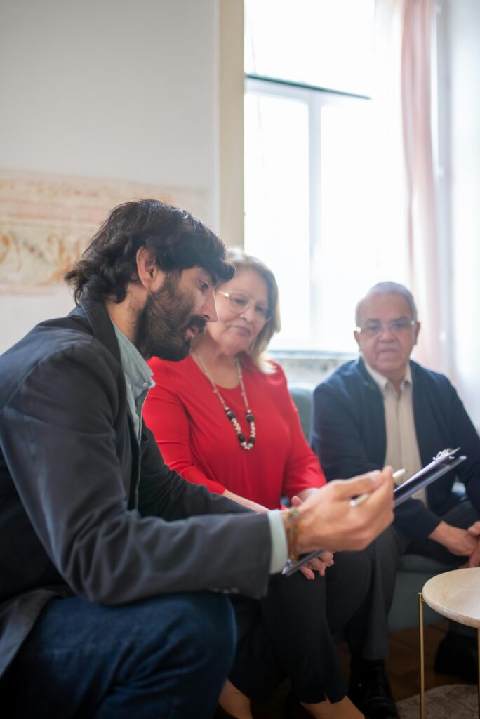 Consulting agent discussing documents with senior couple indoors during a business meeting.